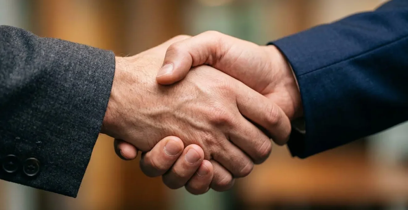 Extreme macro close-up of business partnership handshake showing textural detail and human connection