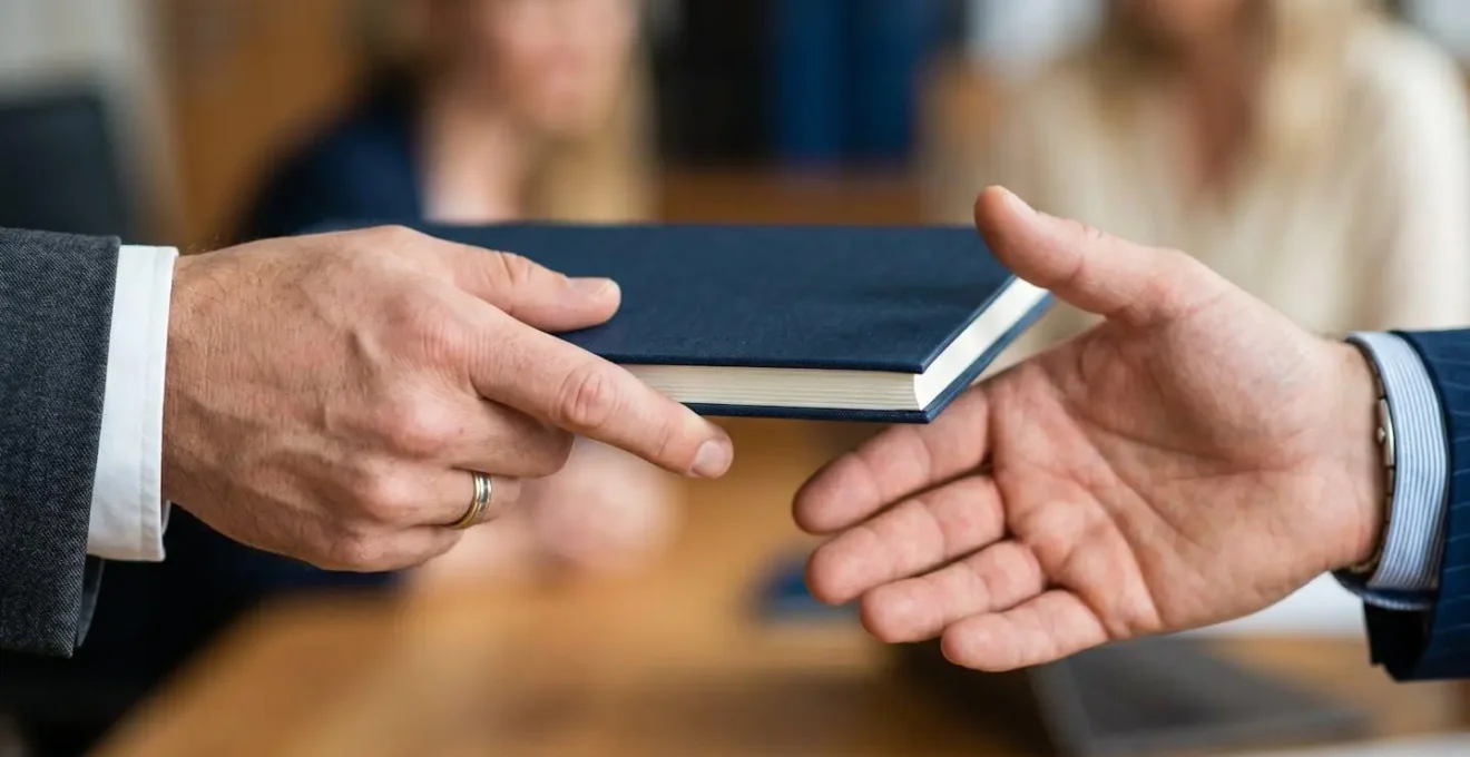 A macro and textural photograph emphasizing contract details and partnership commitment through a close-up perspective of a handshake over a document.