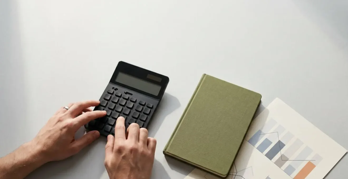 Business professional reviewing partnership financial models with calculator and documents in minimal workspace
